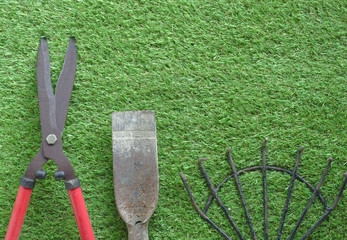 Large grass cutting shears, red handle, steel rake, digging shovel, lawn background Arranged in order