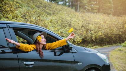 Asian women are on vacation. Drive happily traveling to the Mexican sunflower flower garden in Thailand.