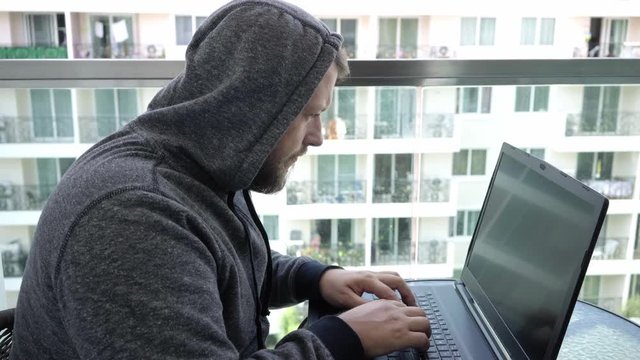 Cybercrime, hacking and technology concept - male hacker writing code or using computer virus program for cyber attack