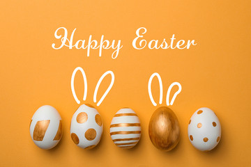Set of traditional Easter eggs decorated with golden paint on color background, top view. Space for text