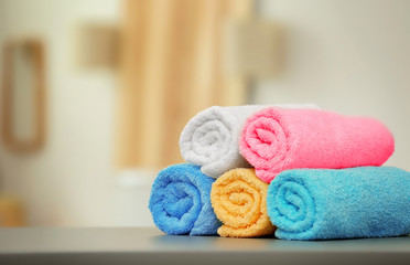 Fototapeta na wymiar Clean towels on table against blurred background