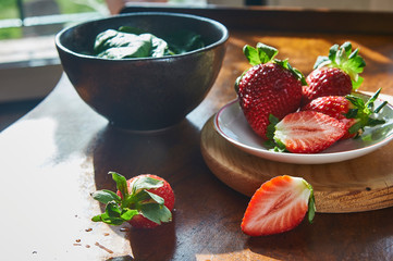 Fresh Strawberry in a plate on a wooden table background