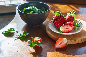 Fresh Strawberry in a plate on a wooden table background