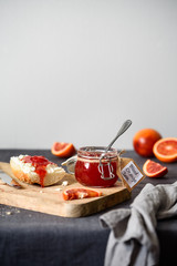 Fototapeta na wymiar Blood orange jam in a jar. Sandwich with ricotta and orange jam.