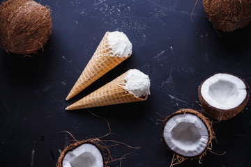 coconut ice cream in a waffle cone on a dark background, view from above