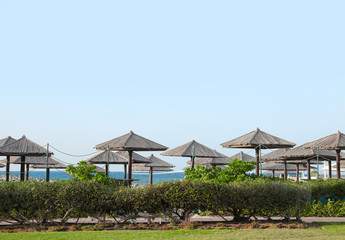 Fototapeta na wymiar Beautiful landscape with beach umbrellas at tropical resort on sunny day
