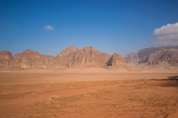 Naklejka na ściany i meble Middle East desert yellow and red big valley nature scenery landscape with steep rocky bare mountain ridge background 