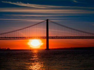 Fototapeta na wymiar Bridge April 25 over the river Tejo. Sunset in Lisbon. Famous bridge of lisbon