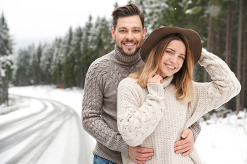 Cute couple outdoors on snowy day. Winter vacation