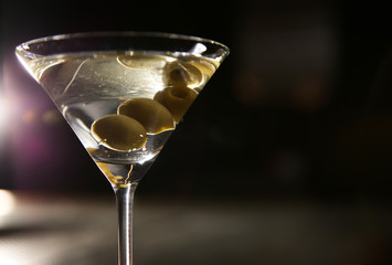 Glass of martini with olives in bar, closeup. Space for text