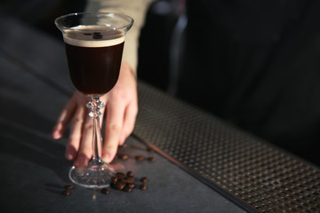 Barman serving espresso martini cocktail at counter, closeup. Space for text