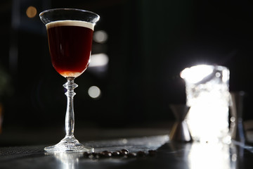 Glass of martini espresso cocktail on bar counter. Space for text