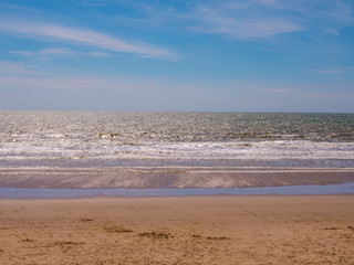 Abstract seascape. Blue summer skies with the sea washing gently onto the sand. Happy holidays.