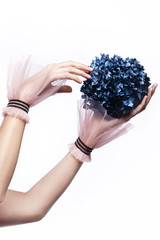 Beautiful female hands in elegant gloves holding flower on white background. Spa facilities.
