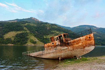 old rusty abandoned boat on lake