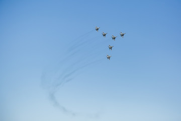 a triangular formation of a group of six russian military fighter jet planes flying high in blue sky