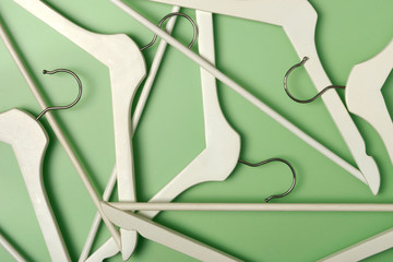 Wooden coat hanger / clothes hanger on a green background. Potential copy space above and inside hanger.