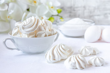 Meringues. Protein sugar cake for tea or coffee. Light background.White morning. Candy