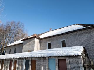 Snow on half the roof of the house. In half. Melting snow on the roof.