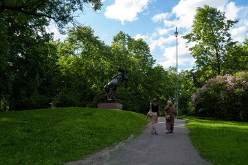 Park with sculpture and two people staring at