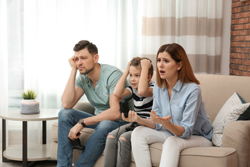 Obraz premium Family playing video games on sofa in living room