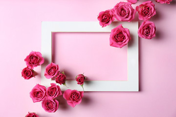 Empty frame with roses on color background, top view. Space for text