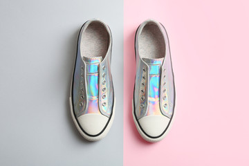 Stylish sneakers on color background, top view