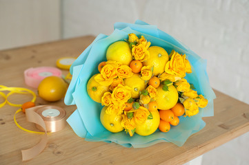 freshly made bouquet of fruit and flowers. Yellow bouquet in blue wrapper