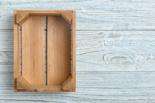 Empty crate on wooden background, top view with space for text