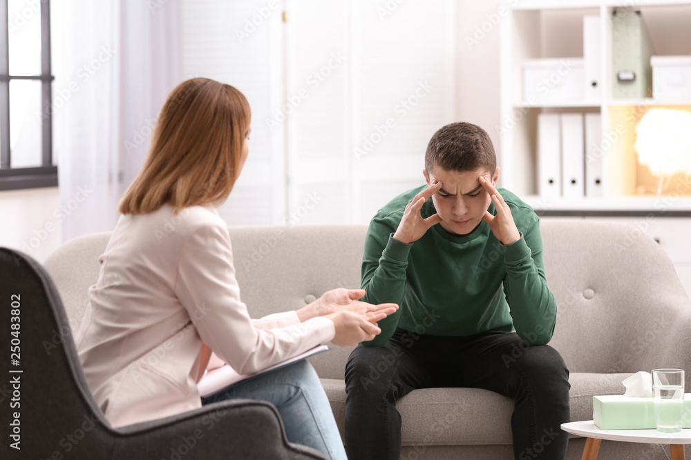 Poster Psychotherapist working with young man in office