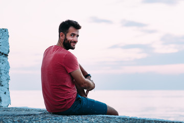 Young man enjoying blue hour by the sea