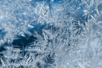 Frosty patterns on the frozen window are macro. Winter background