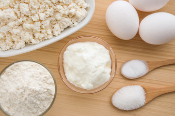 Ingredients on the wooden table, cooking a cheesecake.