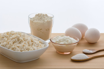 Ingredients on the wooden table, cooking a cheesecake.