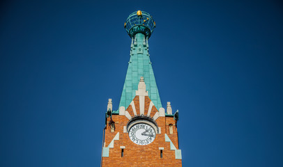A clock tower in Krakow under a blue sky.