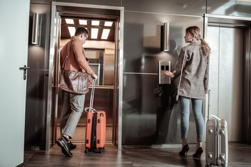 Dark-haired husband entering elevator while going to airport