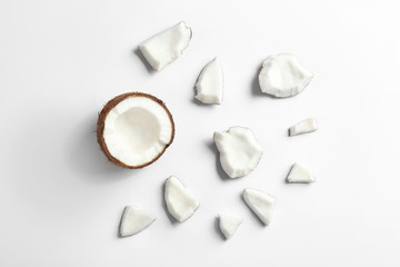 Composition with coconut pieces on white background, top view