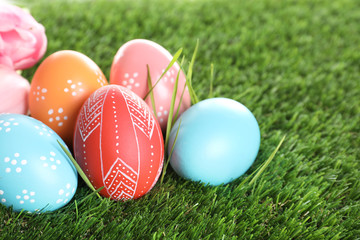 Fototapeta na wymiar Colorful painted Easter eggs on green grass, closeup