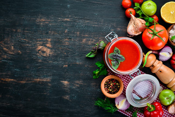 Tomato paste Ketchup with vegetables, homemade. Top view. On a black background. Free space for text.