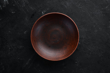 Clay dishes. A plate on a black background. Top view. Free copy space.