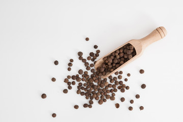 Pimentos on the wooden spoon isolated on white