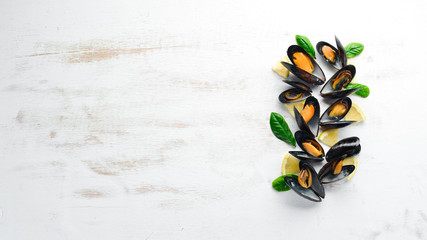 Boiled mussels with spices in a plate. Top view. Free space for your text. On the old background.
