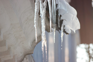 Water drops on the roof. icicles melt under influence of warm air and sun. Spring influence in the...