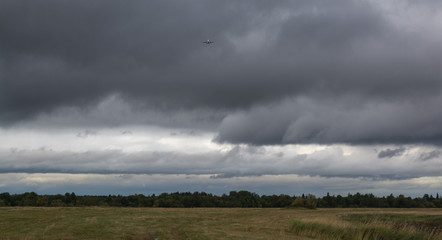 Plane at clouds over the field