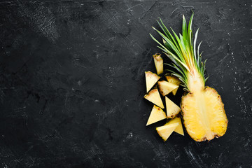 Sliced pineapple on a black background. Tropical Fruits. Top view. Free copy space.