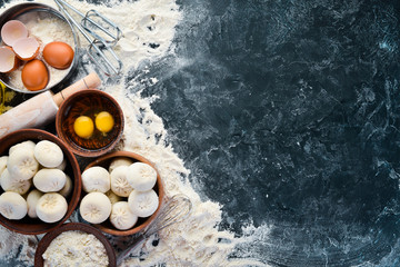 Hinkali Homemade. Flour, eggs, dough on a black background. Top view. Free copy space.
