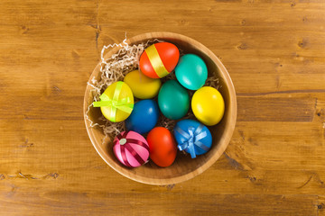 easter eggs in wooden bowl on wooden background