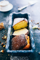 Yogurt plumcake made with almond and gluten free, with colored easter egg, shot from a top viewpoint over a rusty wooden black background,flare added