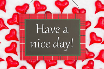 Have a nice day greeting on hanging sign with red hearts on white fabric