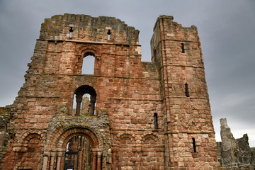 Front of Lindisfarne church and monastery ruins of the medieval priory with cross arrow loops on Holy Island of Lindisfarne England UK